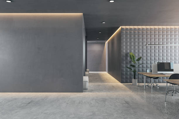 istock An empty, modern office interior with desks, a computer, and decorative plants against a textured wall, set on a concrete floor. 3D Rendering 2148882628