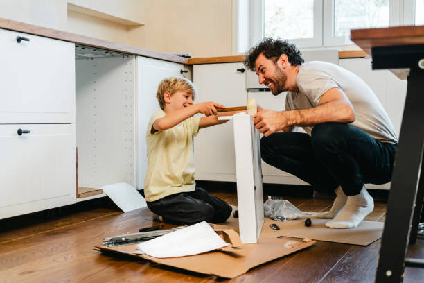 Father and son assembling kitchen furniture stock photo