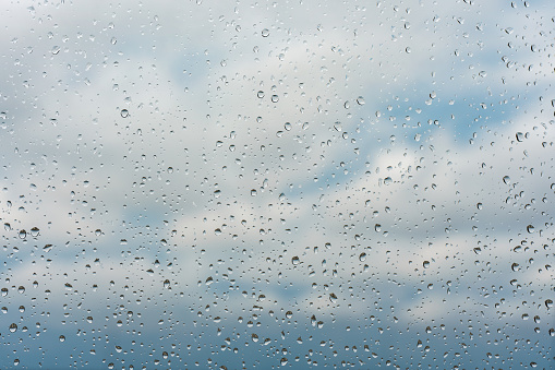 Raindrops on window glass surface, background texture.