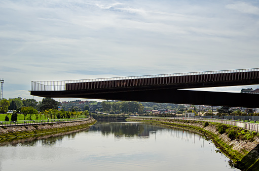 Iron footbridge crosses the estuary to the Niemeyer Cultural Center. Aviles. Asturias, Spain, September 10, 2023.