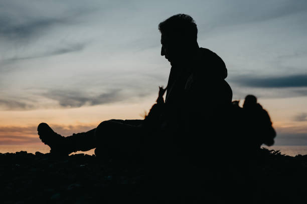A man sitting on the beach at sunset