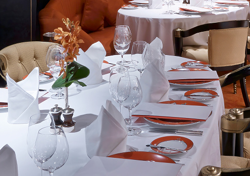 Exquisite table setting with pristine white linen, gleaming glassware, and polished cutlery, ready for a gourmet experience.
