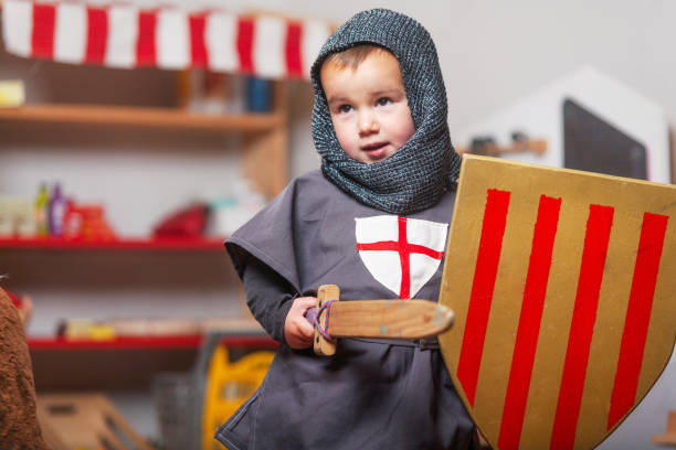 Toddler playing knights in his costume.