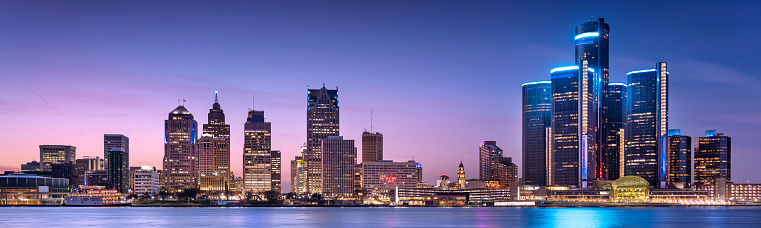 Downtown cityscape panoramic view of Detroit Michigan skyscrapers and modern glass buildings over the river at night