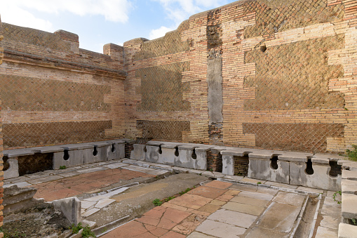 Ancient public toulet in Ostia Antica - ancient roman city and port. Rome, Latium, Italy