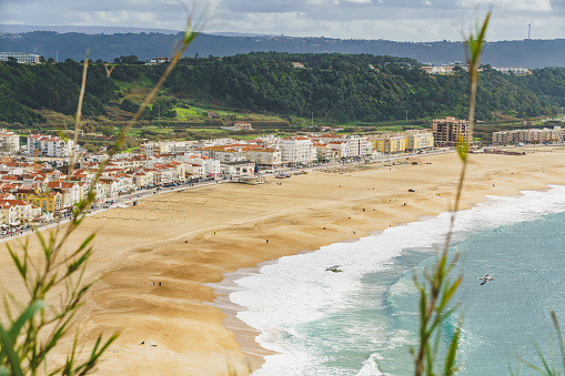Lush greenery frames the dense urban landscape of Nazare, leading to the beach and ocean.