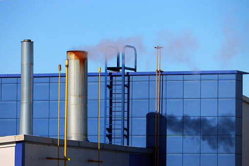 Chimney with smoke, stairs, wall, building facade in blue.
