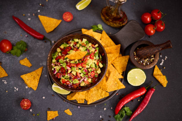 istock traditional salsa dip snack in wooden bowl and corn nacho chips on a table with ingredients 2148896218