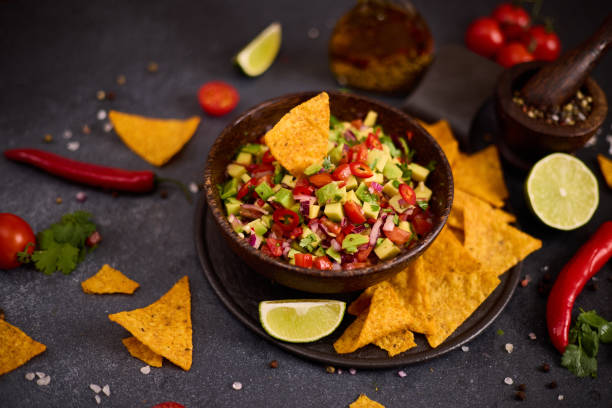 istock traditional salsa dip snack in wooden bowl and corn nacho chips on a table with ingredients 2148896220