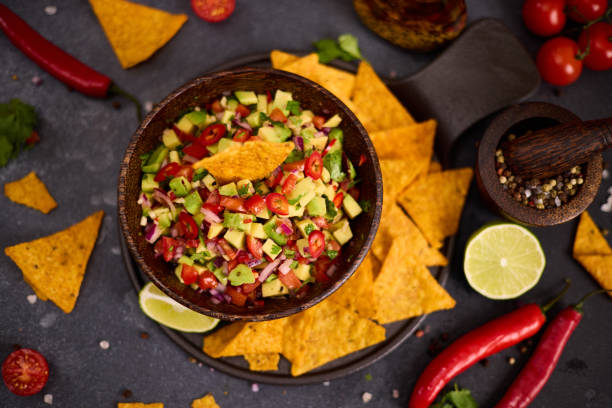 istock traditional salsa dip snack in wooden bowl and corn nacho chips on a table with ingredients 2148896221