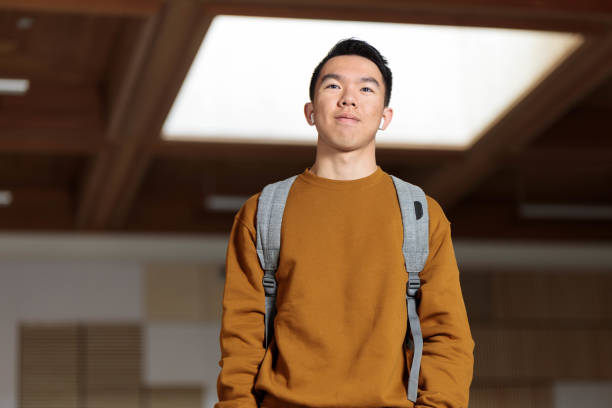istock A college student wearing earphones walking in a classroom 2148896511