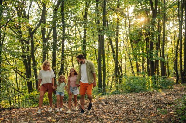 istock A happy family is holding hands in forest and exploring nature. 2148896522