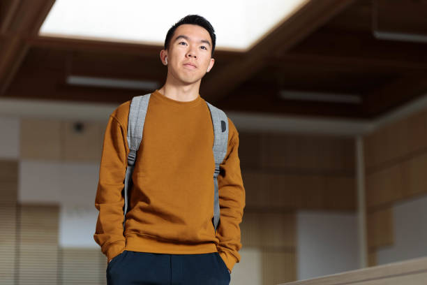 istock A college student wearing earphones walking in a classroom 2148896538