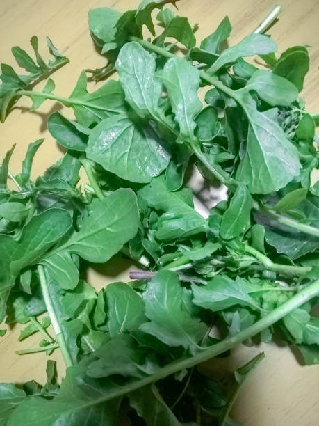 Fresh green arugula leaves on a wooden table. Top view. stock photo