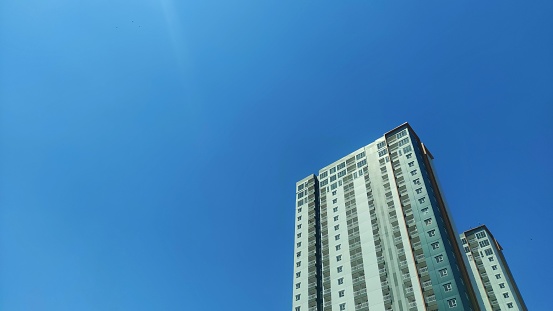A high apartment building in urban area under blue sky during sunny day