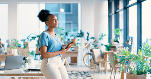 Black woman, creative and thinking with tablet at workplace for ambition, career or startup. Happy African or female person looking out window with smile and technology in wonder or thought at office