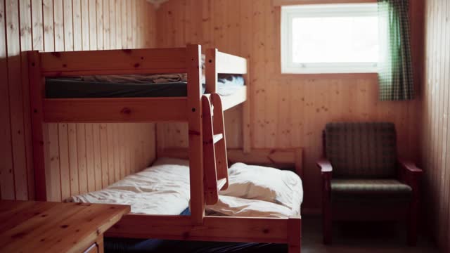 Interior Of A Wooden Cabin Bedroom With Double Bunk Beds. Handheld Shot