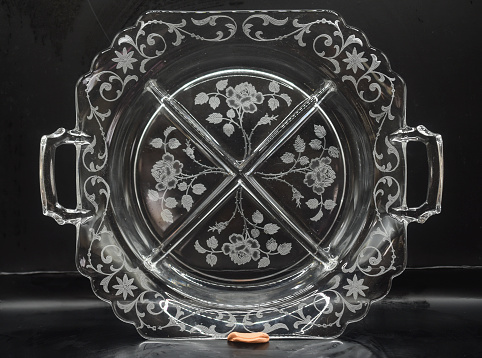 an etched glass  serving platter on a black background