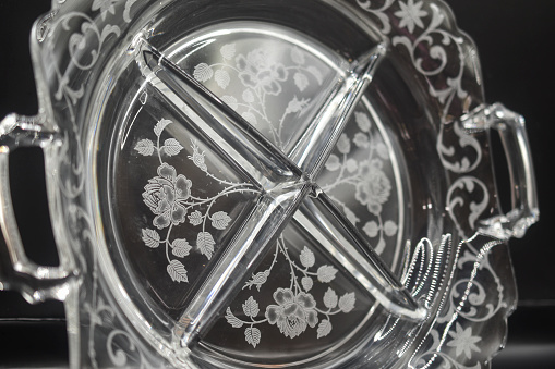an etched glass  serving platter on a black background