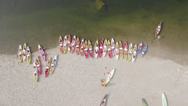 Multiple Canoe Leaving Shore After Camping - Aerial Drone Top Down