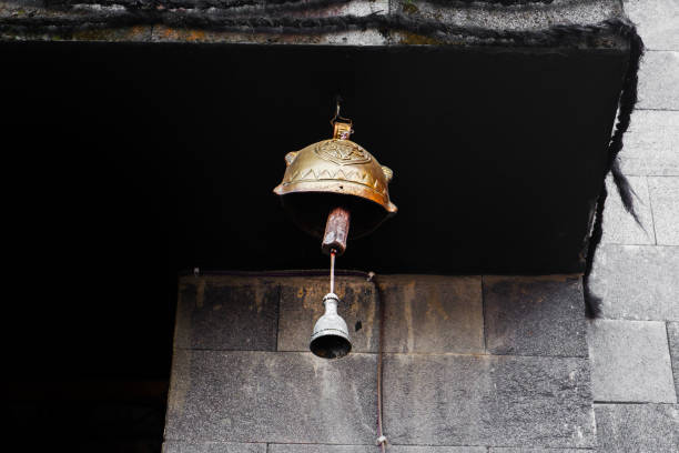 A brass bell hangs in front of the monastery building