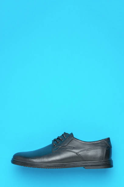 Men's black shoes on a light blue background. Stylish men's shoes.