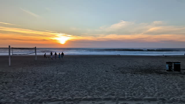Pan across Manhattan Beach at sunset, tourists enjoying coastal charm and golden hues