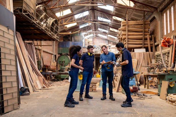 istock Foreman talking to a group of workers at a timber factory 2148914812