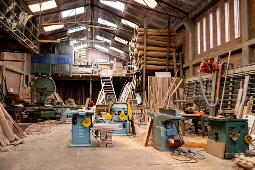 Empty timber factory with manufacturing equipment and planks of wood