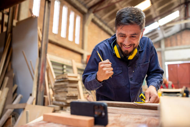 istock Worker at a lumberyard watching a football game while working 2148914867