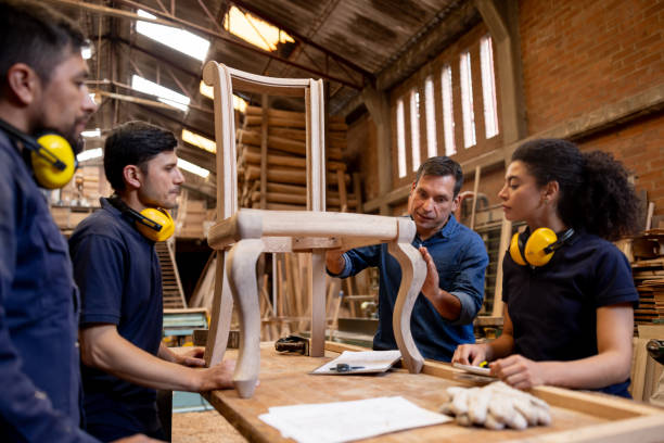 istock Boss talking to a group of workers while manufacturing a chair 2148914915