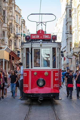 Istanbul, Turkey - July 07, 2014 : The Taksim Tunel Nostalgia Tram trundles along the istiklal street and people at istiklal avenue in centre Istanbul, Turkey