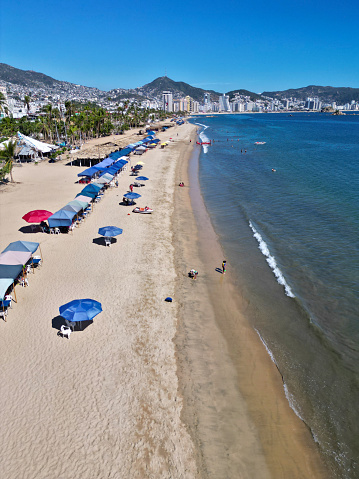 Aerial photograph capturing the tranquil essence of Playa Tamarindos with its line of umbrellas on the Acapulco shore