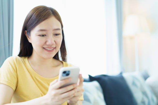 istock Woman working and sending a message on smartphone while living at home. 2148923177