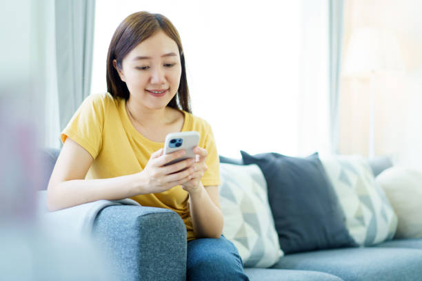 istock Woman working and sending a message on smartphone while living at home. 2148923179