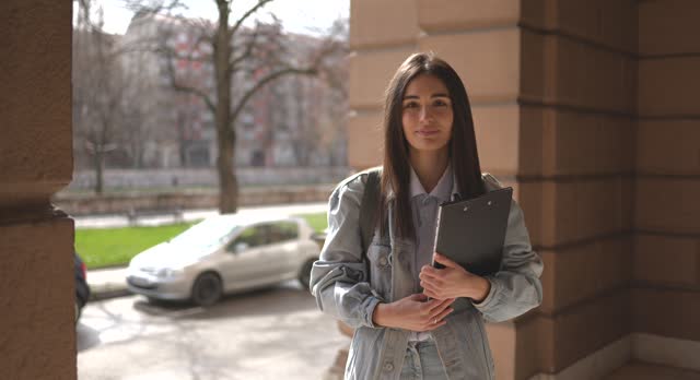 Portrait of female student in front of University building