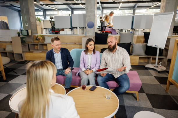 Human resources team interviewing young female job applicant in modern office