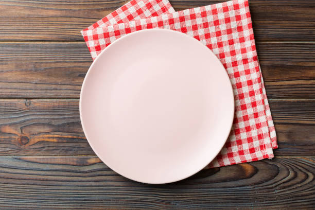 istock Top view on colored background empty round pink plate on tablecloth for food. Empty dish on napkin with space for your design 2148925906