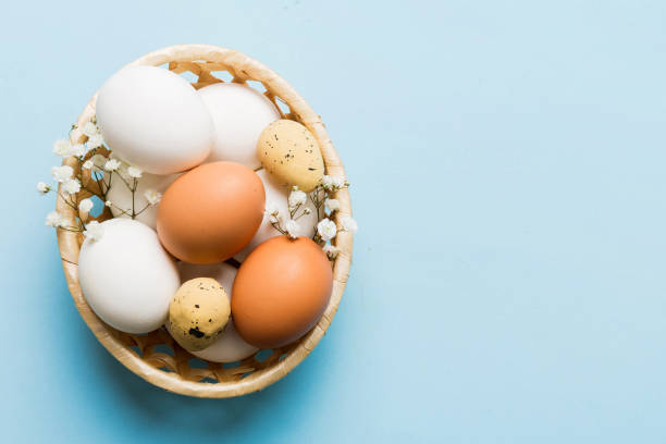 istock Happy Easter composition. Easter eggs in basket on colored table with gypsophila. Natural dyed colorful eggs background top view with copy space 2148925928