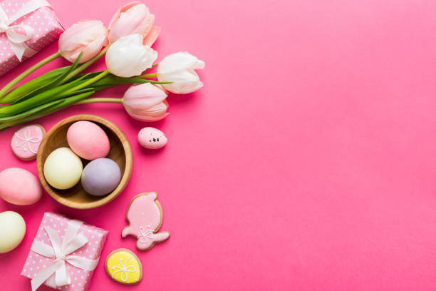 istock Easter frame with eggs, gift box and tulip on a colored background. The minimal concept. Top view Happy Easter composition. Card with a copy space of the place for the text 2148925977