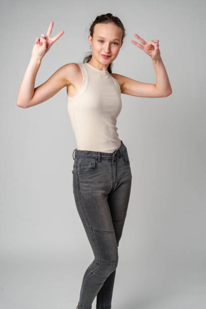 istock Young Girl Making a Peace Sign on gray background 2148926440