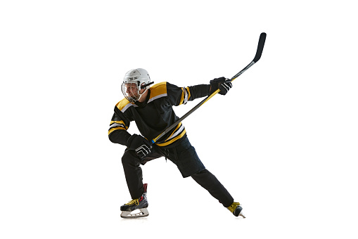 Competitive young man, hockey player in black uniform training, playing isolated on white background. Concept of professional sport, competition, game, tournament, active lifestyle