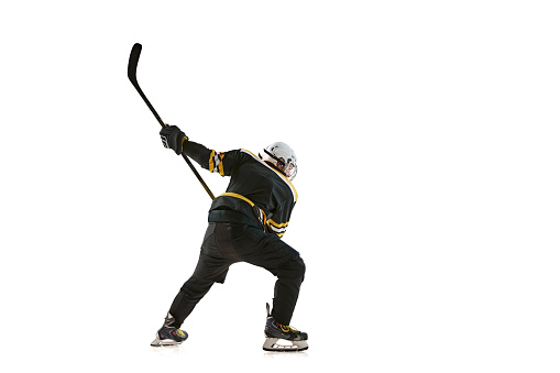 Competitive young man, hockey player in motion during game, training, competing isolated on white background. Concept of professional sport, competition, game, tournament