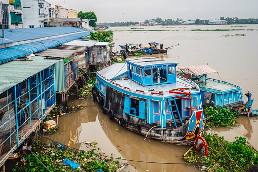 blue vessels anchoring at market in vinh long city in the mekong delta, vietnam