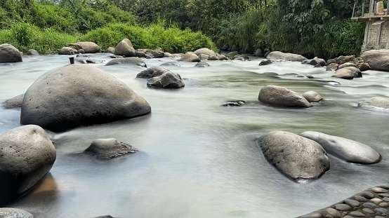 River in long exposure shot with Surrounding Forest and Rocks