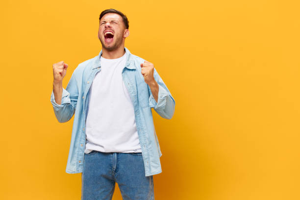 istock Crazy aggressive irritated angry tanned handsome man in blue basic t-shirt scream posing isolated on orange yellow studio background. Copy space Banner Mockup. People emotions Lifestyle concept 2148930449