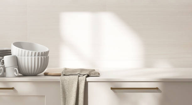 istock Beige kitchen table counter, stack of white bowl on countertop in sunlight on wood pattern tile wall in background 2148931406