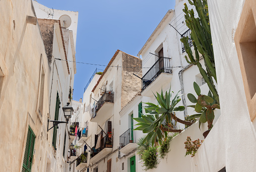 The charming, narrow lanes of old Eivissa town in Ibiza, where traditional white buildings meet the bright Mediterranean sun