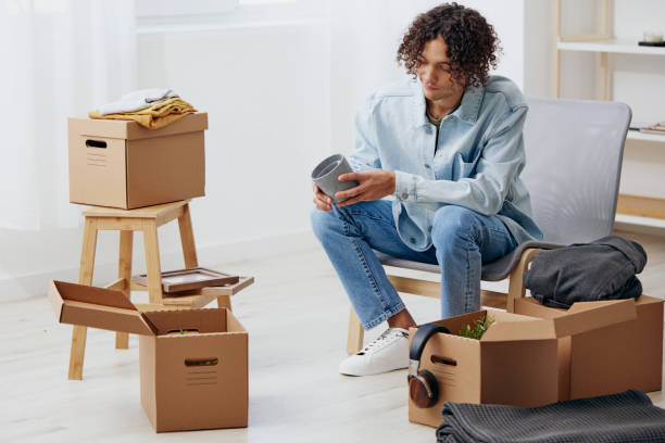 istock A young man unpacking things from boxes in the room sorting things out 2148933953