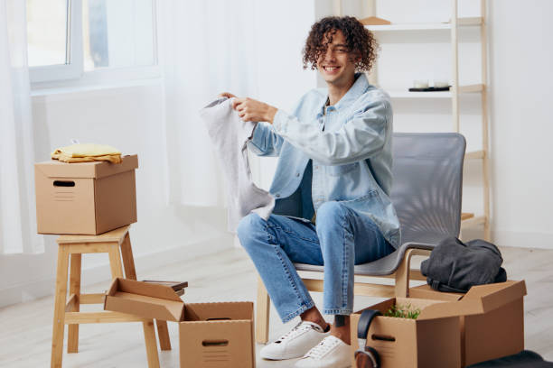 istock A young man sitting on a chair with boxes interior moving 2148934221